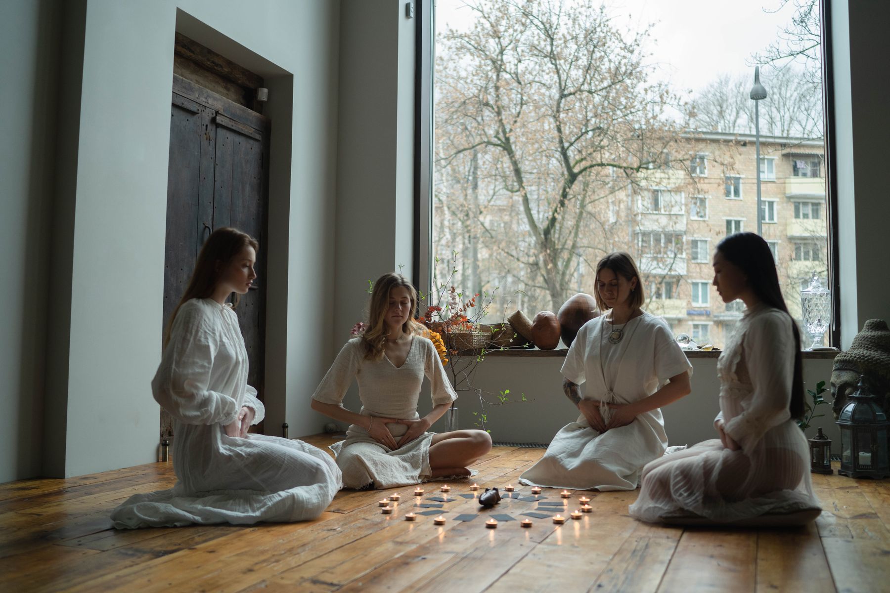 Círculo de personas sentadas alrededor de velas encendidas