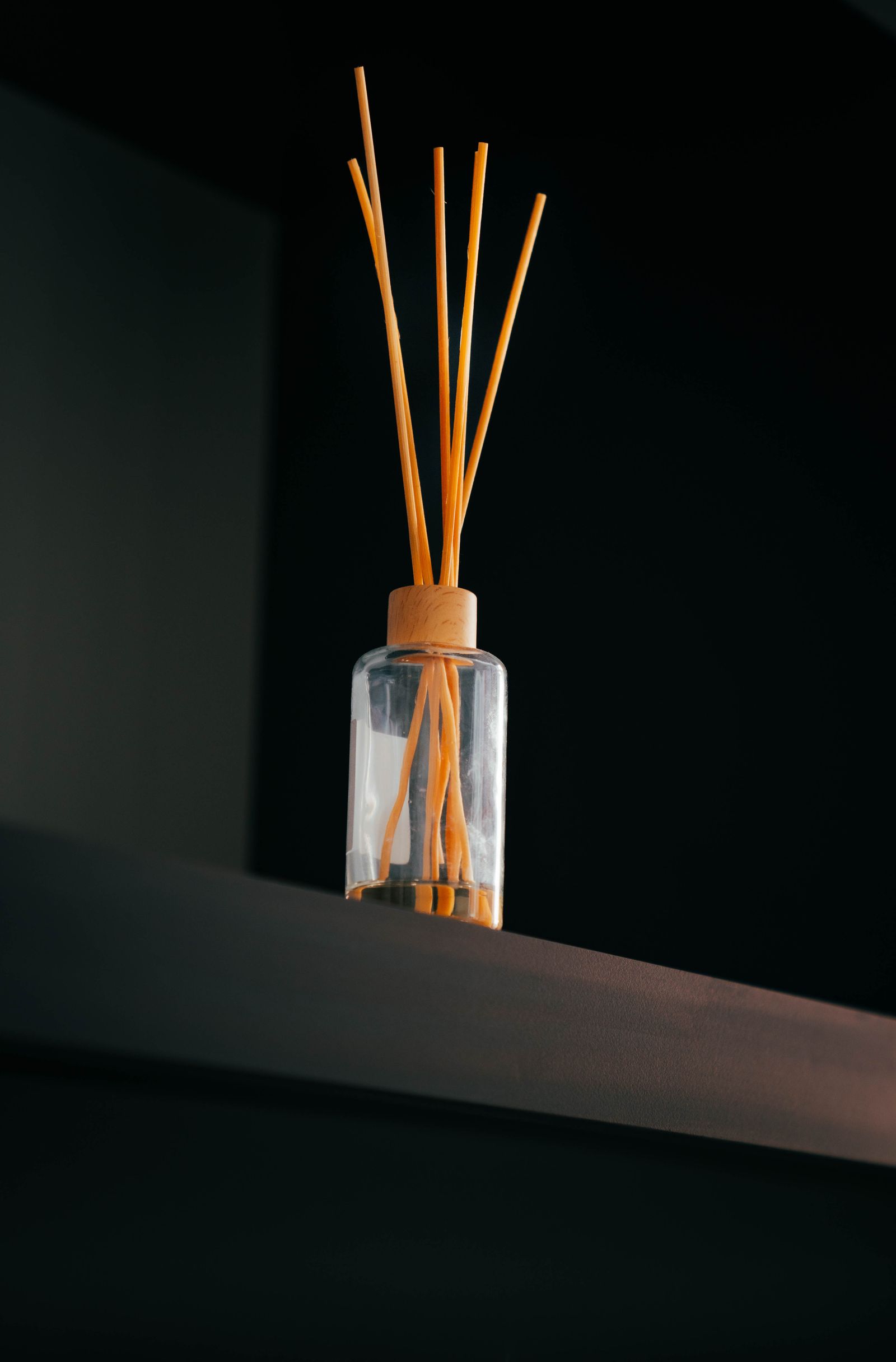 Difusor de varillas de madera sobre un estante oscuro